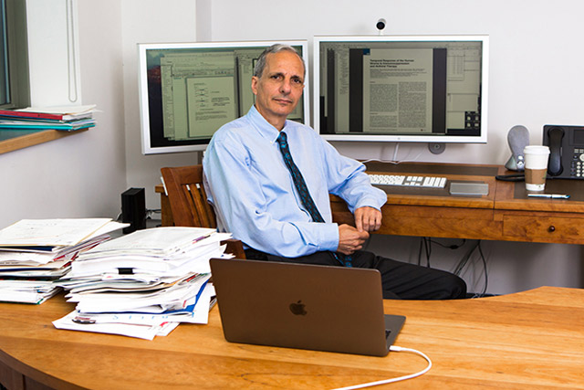 Doctor-Robert-Darnell-sits-behind-his-desk-at-the-New-York-Genome-Center